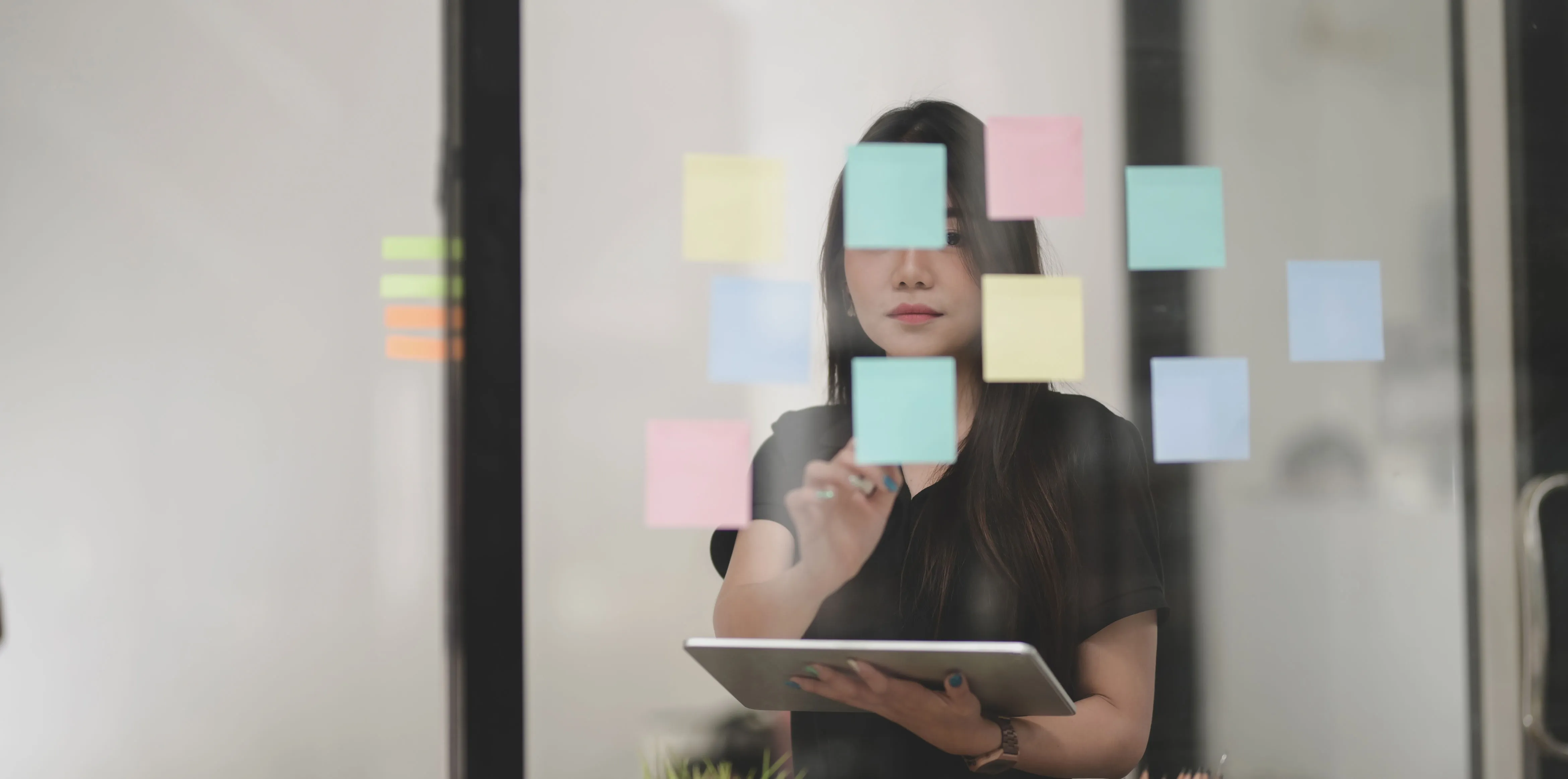 Person arranging sticky notes to show habits that keep capital decisions close to purpose.