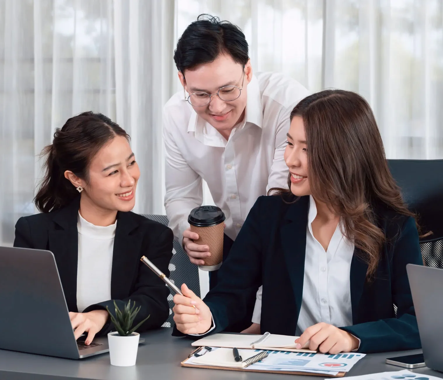 Colleagues reviewing reports in a discussion about suitable clients and enquiries.