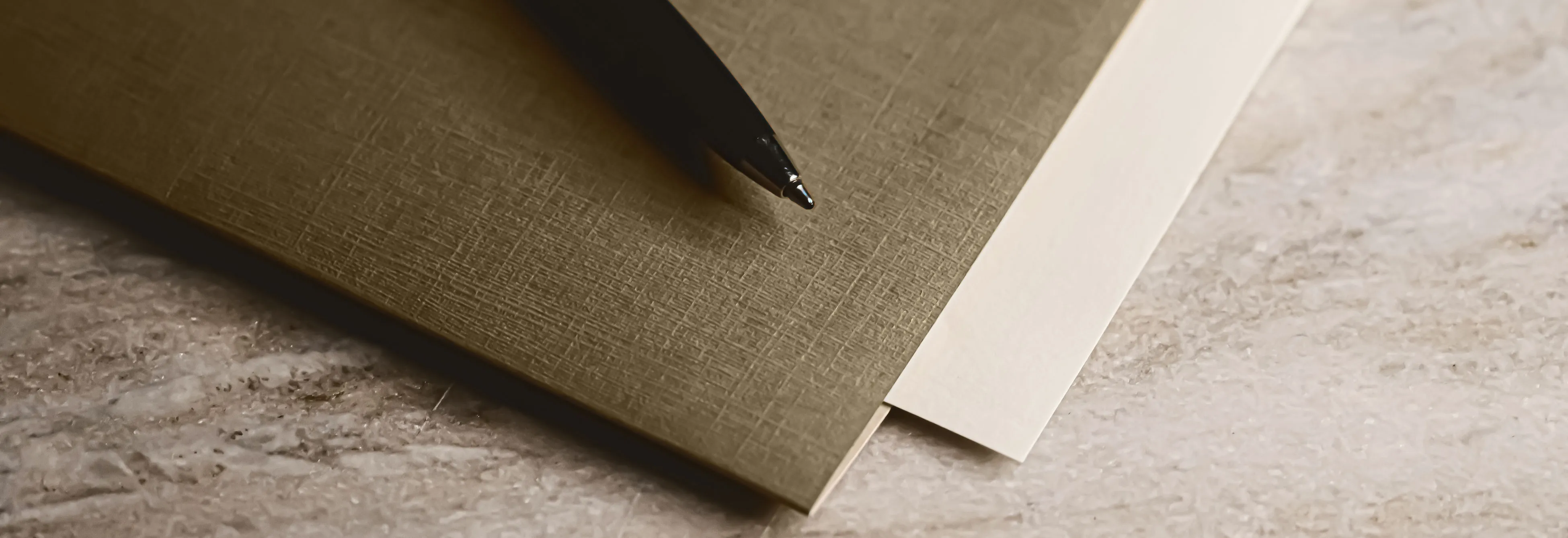 Pen beside a notebook for recording continuity through structural change.