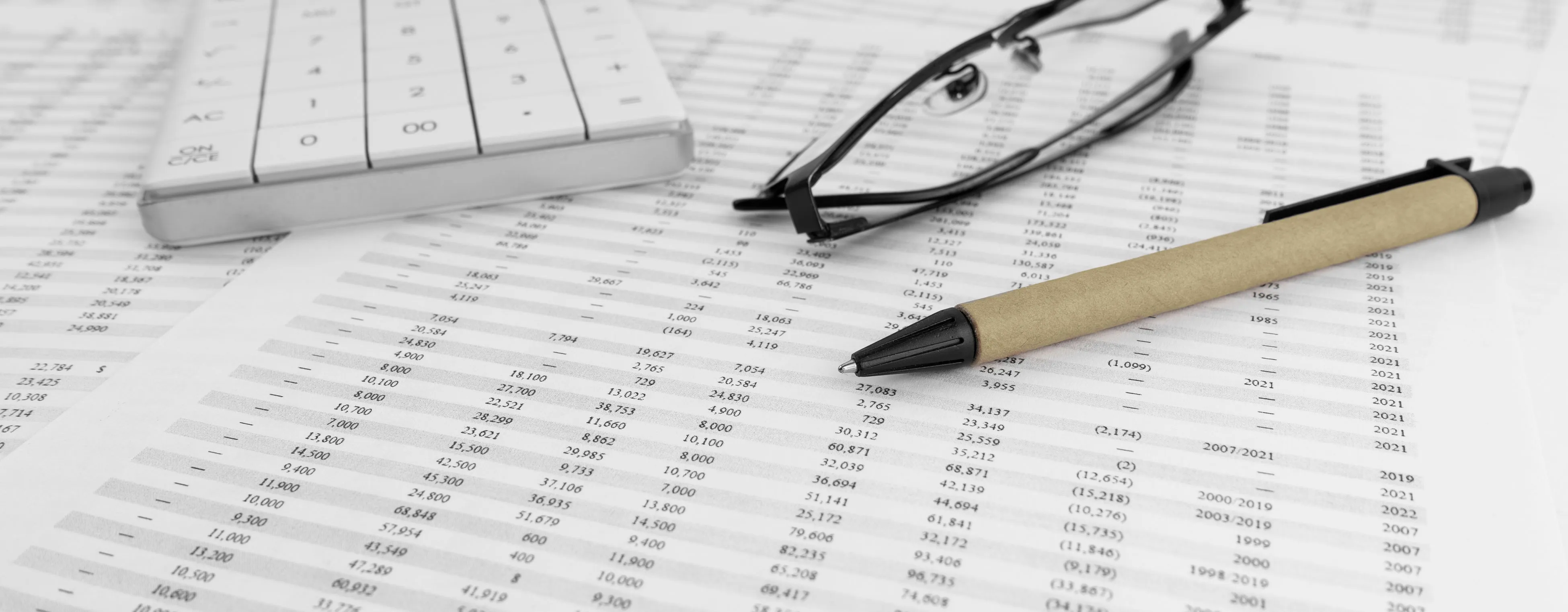 Calculator, glasses and financial documents for organising corporate reserve capital around liquidity discipline.